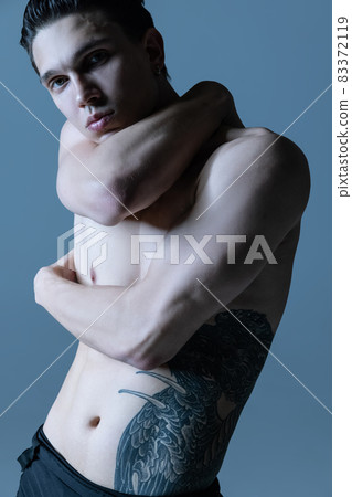 Close-up young muscled man, male ballet dancer posing isolated on old navy studio background. Art, motion, inspiration concept. Close-up young muscled man, male ballet dancer posing isolated on old navy studio background. Art, motion, inspiration concept. 83372119