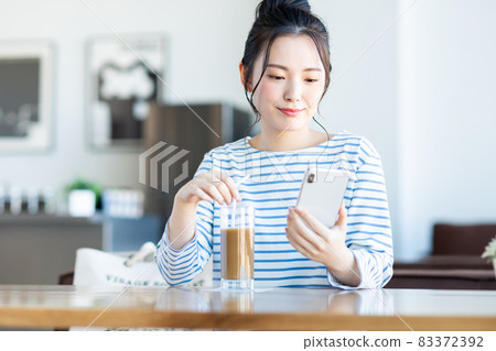 A young woman watching a smartphone at a cafe 83372392
