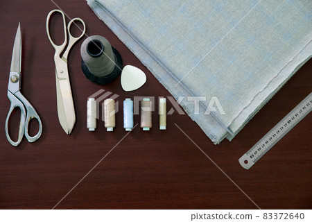 Group of sewing objects lying on a wooden table, flat lay concept of tailor shop 83372640