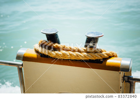 boat bollard (bitt) with rope against water background boat bollard (bitt) with rope against water background 83372840
