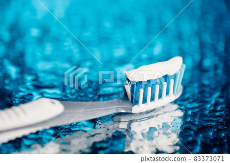 toothbrush on blue background with water drops toothbrush on blue background with water drops 83373071