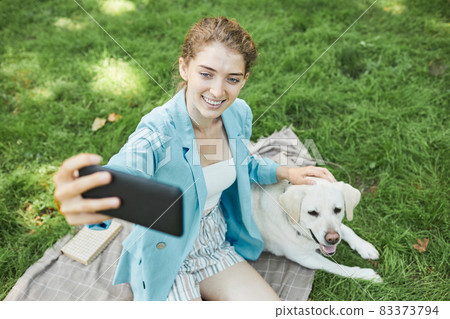 Woman Taking Photo with Dog 83373794