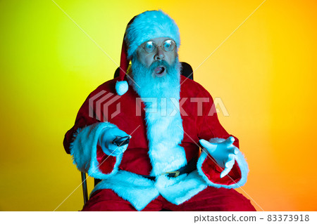 Portrait of senior man, surprised Santa Claus sitting and watching movie at cinema, indoors. Happy New Year 2022, Christmas concept Portrait of senior man, surprised Santa Claus sitting and watching movie at cinema, indoors. Happy New Year 2022, Christmas concept 83373918