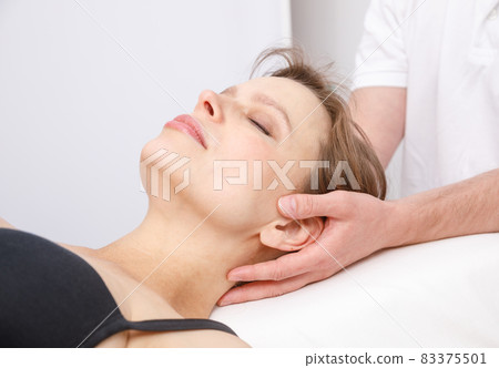 Woman receiving osteopathic treatment of her neck 83375501