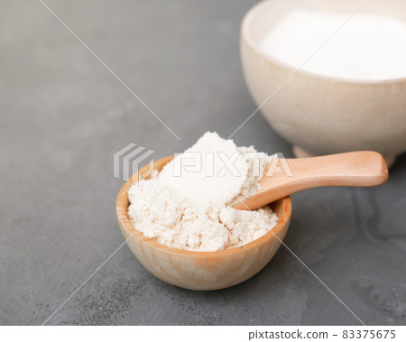 coconut flour in a wooden plate and a spoon. alternative flour for keto meal and LCHF diet. ingredient for healthy gluten free baking. coconut flour in a wooden plate and a spoon. alternative flour for keto meal and LCHF diet. ingredient for healthy gluten free baking. 83375675