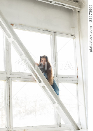 Young girl child climbing on high balk. Danger and hazard concept. Children home hazards. Staged photo. 83375963