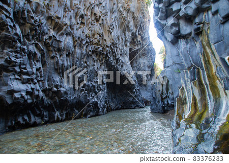 Gole Alcantara Sicilian national park. Alcantara river gorge canyon with volcanic lava caves and rocks. A touristic attraction in Sicily Italy Gole Alcantara Sicilian national park. Alcantara river gorge canyon with volcanic lava caves and rocks. A touristic attraction in Sicily Italy 83376283