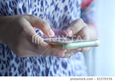 close up of women hand holding smart phone  83376556