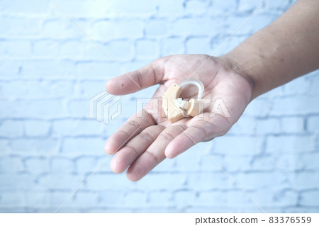 Hearing aid equipment on hand with copy space Hearing aid equipment on hand with copy space 83376559
