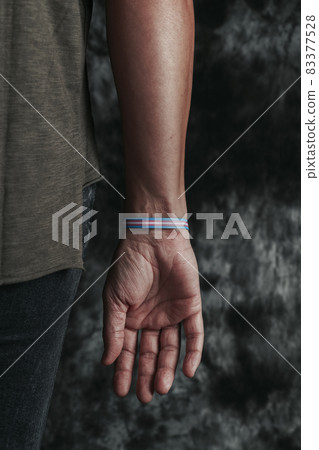 person wears a transgender pride wristband 83377528