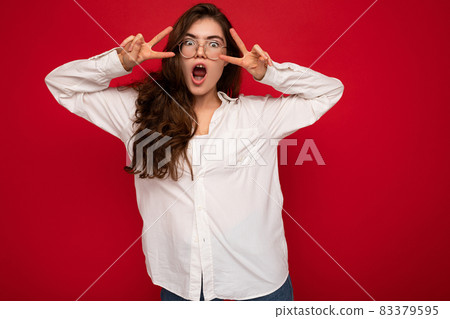 Shot of attractive positive happy joyful funny young curly brunette woman wearing white shirt and Shot of attractive positive happy joyful funny young curly brunette woman wearing white shirt and 83379595