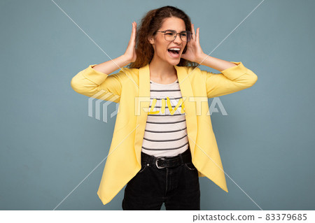 Photo of young emotional angry attractive brunette curly woman with sincere emotions wearing stylish Photo of young emotional angry attractive brunette curly woman with sincere emotions wearing stylish 83379685
