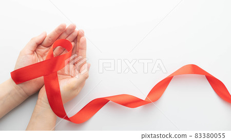 World AIDS day in December month campaign. Human hands holding red ribbon awareness on white background. Symbol of awareness and support for people living w HIV and STD. Healthcare concept. 83380055