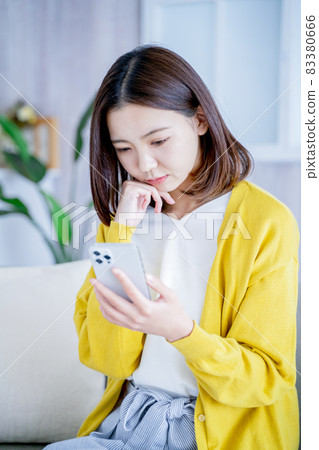 在家觀看智能手機的婦女 在家觀看智能手機的婦女 83380666