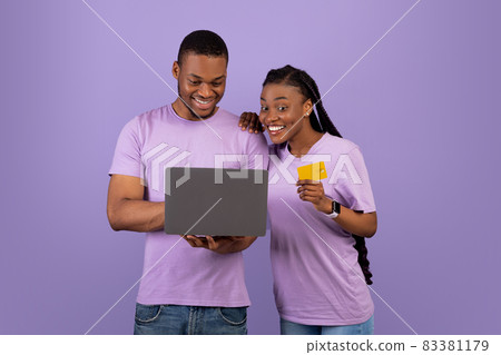 Black family using computer and credit card at violet studio 83381179
