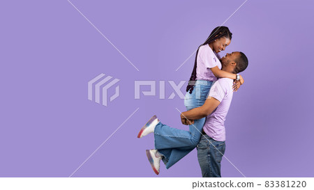 African American man lifting his girlfriend up at studio 83381220