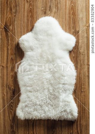 sheepskin carpet on wooden background sheepskin carpet on wooden background 83382904