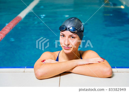 Young smiling woman swimmer in indoor swimming pool 83382949