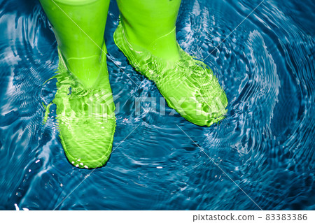 green rubber boots in the water green rubber boots in the water 83383386