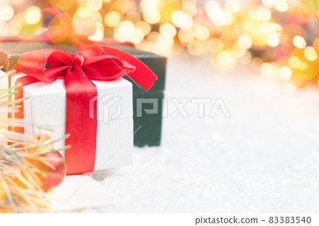 Beautiful Christmas gifts with pine branch, snow and bokeh lights on the background with copy space. Post card, discount voucher or sale concept.  83383540