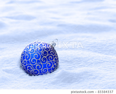 Blue christmas ball on snow. Winter background 83384337