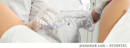 Cropped panorama of gynecologist examining a patient who is sitting in a gynecological chair. Female health concept. 83384581