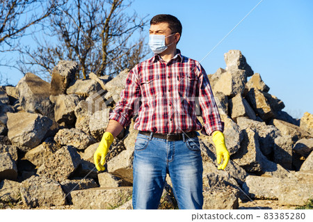 a man works with a pile of stones and broken pieces of concrete, carries construction debris a man works with a pile of stones and broken pieces of concrete, carries construction debris 83385280
