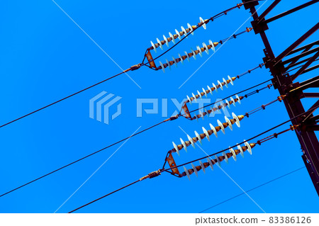 High voltage pole isolated on blue background 83386126