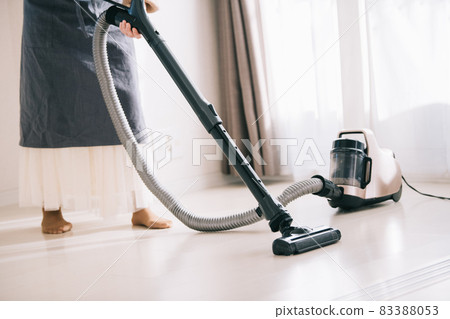 Woman vacuuming flooring Woman vacuuming flooring 83388053