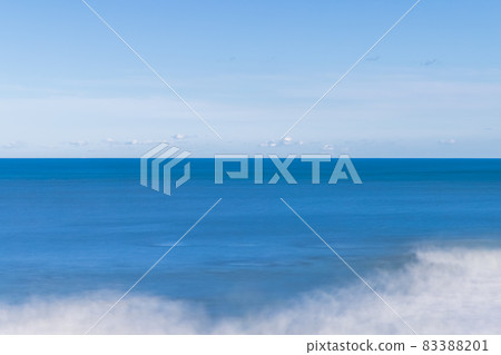 由藍天和藍海創造的地平線和海浪逼近，長時間曝光所創造的白色抽象 83388201