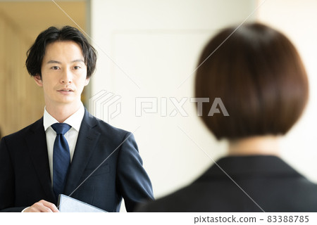 Men and women in suits passing each other in the corridor Men and women in suits passing each other in the corridor 83388785