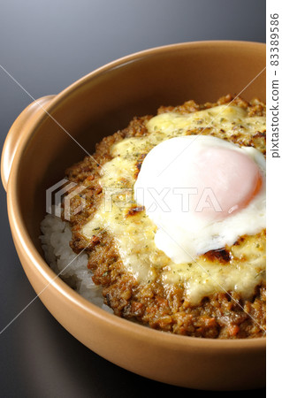 Photographed a grilled dry curry with hot spring eggs and cheese on a black background 83389586
