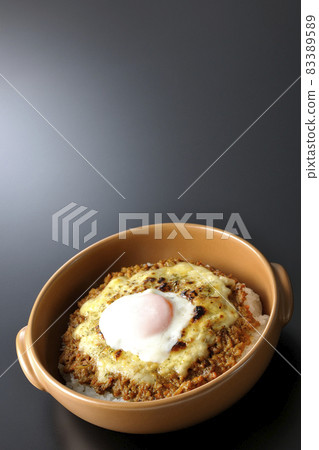 Photographed a grilled dry curry with hot spring eggs and cheese on a black background 83389589