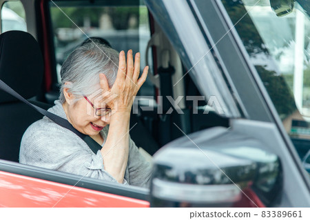 Elderly woman driving a car 83389661