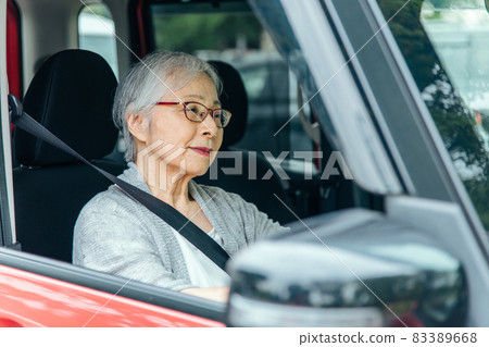 Elderly woman driving a car (smiles) Elderly woman driving a car (smiles) 83389668