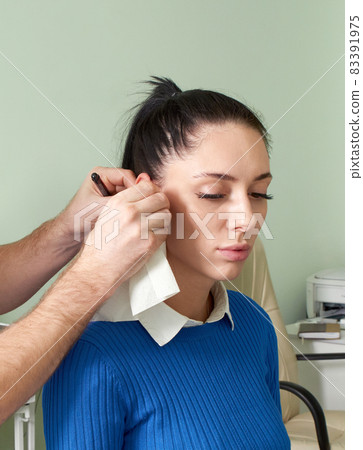 Attentive ent doctor doing ear exam of pretty woman 83391975