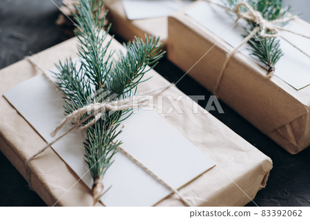 minimal style christmas wrapping of gifts. paper present decor. eco gifts with natural fir tree decoration on grey background 83392062