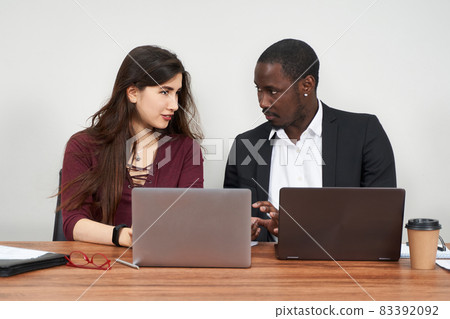 Multiethnic Colleagues Use Cellphones and Try Smartphone Applications In Office 83392092