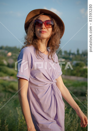 Young girl in dress is having great time during vacation in the summer on sky background in nature, travelling concept 83393280
