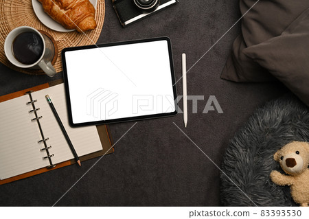 Digital tablet, notebook and teddy bear on gray carpet. Digital tablet, notebook and teddy bear on gray carpet. 83393530