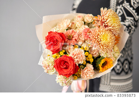 Beautiful bouquet of mixed flowers in woman hand. Floral shop concept . Beautiful fresh cut bouquet. Flowers delivery Beautiful bouquet of mixed flowers in woman hand. Floral shop concept . Beautiful fresh cut bouquet. Flowers delivery 83393873