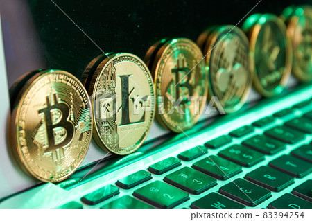 Close-up various golden cryptocurrency coins in a row. 83394254