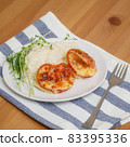 Baked cutlets with tomatoes and cheese with rice on plate 83395336