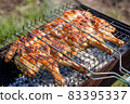 Chicken grilled on a charcoal barbeque brazier 83395337