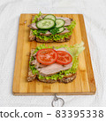 Fresh sandwiches with baked meat and vegetables on cutting board 83395338