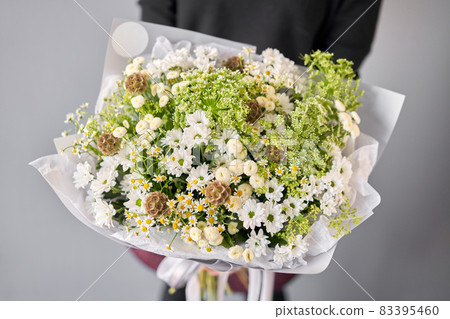 Beautiful bouquet of mixed flowers in woman hand. Floral shop concept . Beautiful fresh cut bouquet. Flowers delivery Beautiful bouquet of mixed flowers in woman hand. Floral shop concept . Beautiful fresh cut bouquet. Flowers delivery 83395460