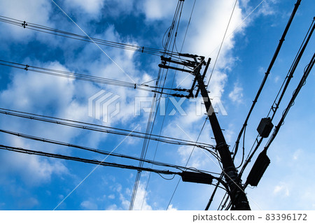 Blue sky, utility pole and wire background 83396172