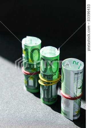 Close up of Euro money roll. Euro banknote set cash money - EU currency. Rolled with rubber euro notes. Banknotes stacked on each other in different positions Close up of Euro money roll. Euro banknote set cash money - EU currency. Rolled with rubber euro notes. Banknotes stacked on each other in different positions 83396433