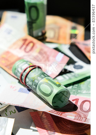 Close up of Euro money roll. Euro banknote set cash money - EU currency. Rolled with rubber euro notes. Banknotes stacked on each other in different positions Close up of Euro money roll. Euro banknote set cash money - EU currency. Rolled with rubber euro notes. Banknotes stacked on each other in different positions 83396437