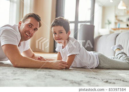 Smiling dad enjoying time with son at home 83397384